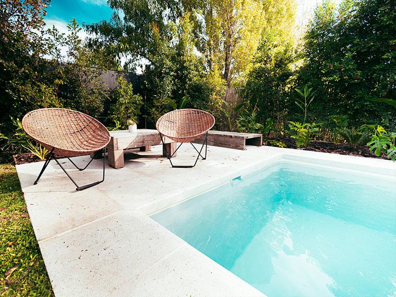 Backyard pool with two chairs